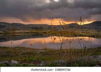 
In Arctic Tundra Summer Polar Night In Sky Is Cloudy And  Sky And Hills Are Reflected In  Small Lake