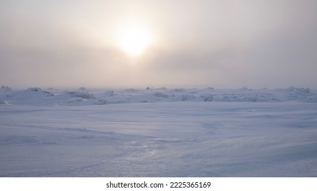 An Arctic winter landscape as the sun sets over the frozen tundra, near Churchill, Manitoba, Canada.