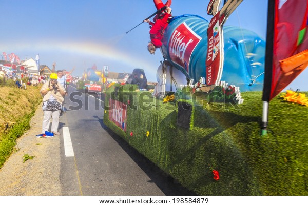 ARDEVON,FRANCE-JUL 10:A truck advertising Vittel\
water spray the fans and generate a rainbow during the passing of\
the publicity caravan in the the stage 11 of Le Tour de France on\
July 10,\
2013