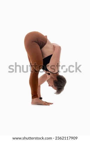 Ardha Baddha Padmottanasana (Half Bound Lotus Forward Fold), Ashtanga yoga  Side view of woman wearing sportswear doing Yoga exercise against white background. 