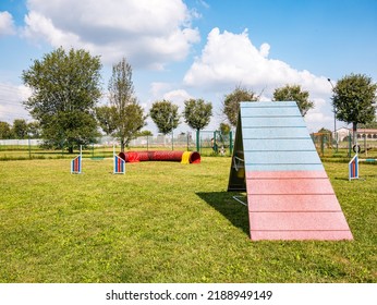 Area equipped for dog training. Dog training in a fenced area.
Obstacle courses with tunnels, steep ramp, slides, poles and high jump. Horizontal view. - Powered by Shutterstock