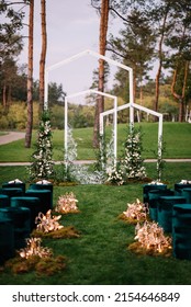 in the area of the wedding ceremony in a pine forest on the green grass in the summer there are wicker chairs, the ceremony is decorated with flower arrangements and decor. Velour seats 