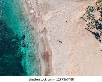 Areal View of Person Standing on Casares Beach in Málaga, Andalusia with Turquoise Water and Palm Trees