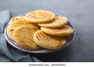 Arepa Is A Type Of Meal Made From Cornmeal, Traditional In The Cuisine Of Colombia And Venezuela On A Gray Background