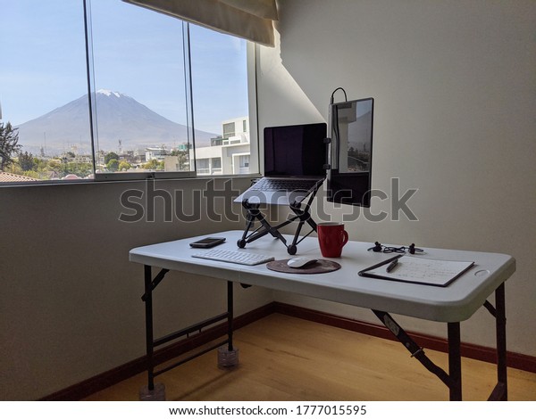 Arequipa, Arequipa, Peru. July 6th 2020. Clean and\
ergonomic home office set up. Great view of Misty Volcano. Digital\
Nomad portable office set\
up.
