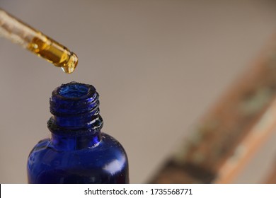 Argan Oil. Argan Oil In Glass Dropper And Blue Glass Bottle. 