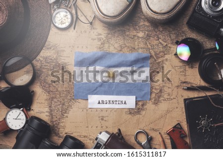 Argentina Flag Between Traveler's Accessories on Old Vintage Map. Overhead Shot