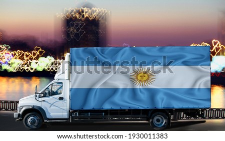 Argentina flag on the side of a white van against the backdrop of a blurred city and river. Logistics concept