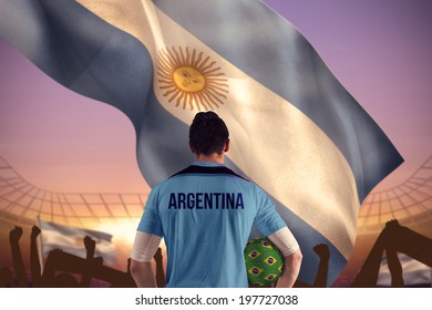 Argentina Football Player Holding Ball Against Large Football Stadium Under Purple Sky