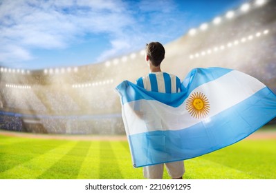 Argentina football supporter on stadium. Argentinian fans on soccer pitch watch team play. Young football player with flag and national jersey cheering for win. Championship game. Vamos Argentina