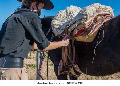 Argentine Gaucho Fixing Horse Saddle