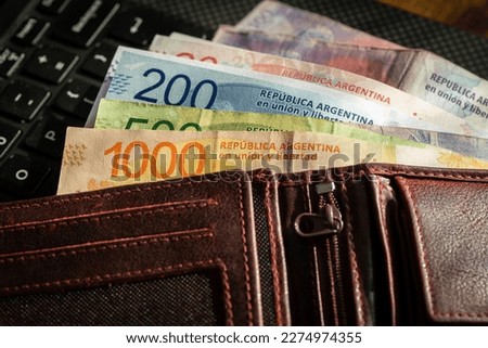 Argentine pesos, a wallet with money lying on a computer keyboard