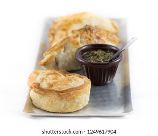 Argentinean Empanadas With Chimichurri Sauce On A Metal Plate