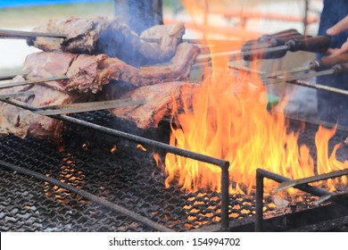 Argentinian cooking meat on grill and spit