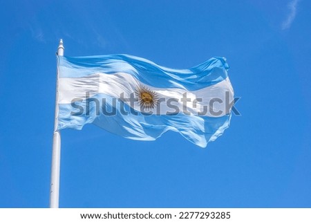 Argentinian flag waving in the blue sky.