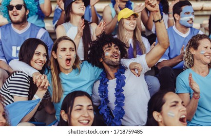 Argentinian spectators in stadium cheering their national football team. People from Argentina in fan zone cheering for their soccer team. - Powered by Shutterstock