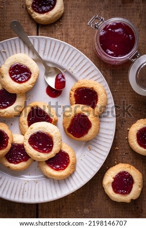 Argentinian traditional cookies called Pepas filled with jam placed on white plate and old wooden table