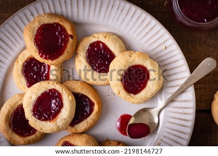 Argentinian traditional cookies called Pepas filled with jam placed on white plate and old wooden table