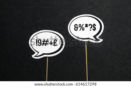 Argument, fight, curse or swearing concept. Disagreement on an online forum or internet. Two speech bubbles argue.. Speech balloon cut from paper of cardboard with wooden stick on a dark background.