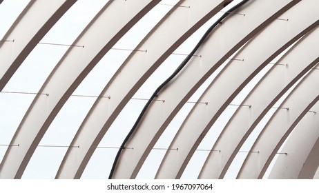 Arhced Steel Structure Painted In White With Tension Rod Connecting The Structure Together To Carry A Bridge