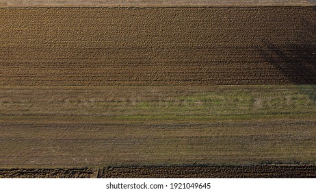 Arial Drone View Of Freshly Plowed Field Ready For Seeding And Planting In Spring.  Farmland. Empty Plowed Farm Land Prepared For The New Crop. Agriculture. Brown Black Soil Near Village.