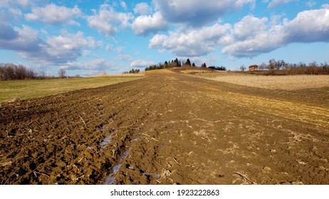 Arial Drone View Of Freshly Plowed Field Ready For Seeding And Planting In Spring.  Farmland. Empty Plowed Farm Land Prepared For The New Crop. Agriculture. Brown Black Soil Near Village.