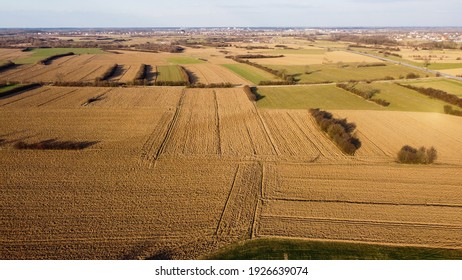 Arial Drone View Of Freshly Plowed Field Ready For Seeding And Planting In Spring. Empty Plowed Farm Land Prepared For The New Crop. Agriculture. Brown Soil Near Village. Farmland. 