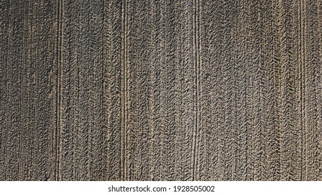 Arial Drone View Of Freshly Plowed Field Ready For Seeding And Planting In Spring.  Farmland. Empty Plowed Farm Land Prepared For The New Crop. Agriculture. Brown Black Soil Near Village.