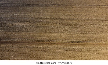 Arial Drone View Of Freshly Plowed Field Ready For Seeding And Planting In Spring.  Farmland. Empty Plowed Farm Land Prepared For The New Crop. Agriculture. Brown Black Soil Near Village.