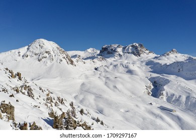 Arial Shot Of A Mountain Landscape In Winter In The Ski Resort Of La Plagne In The French Alps On A Sunny Day. 