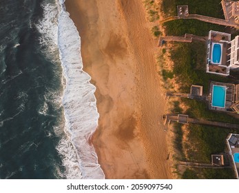 Arial Shot Of The Outer Banks Coastline During The Summer With The Waves Crashing On The Beach With Houses Set Along The Water