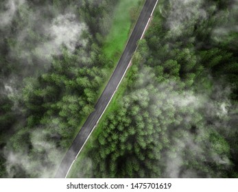 Arial Veiw Of Empty Road In Green Foggy Alpine Forest. Drone Shot