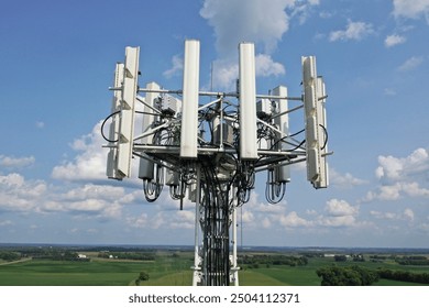 Arial view of a telecom self support tower antennas and radios. Drone photo of cell tower in green field. Scenic view in summer