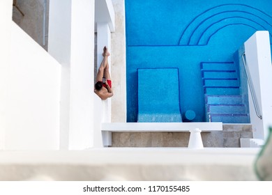 Ariel Shot Of An Attractive And Athletic Young Man Lounging Next To A Swim Up Pool In A Hotel Texting Or Using A Cellphone Or Mobile Phone On A Luxury Holiday Or Vacation In Mexico