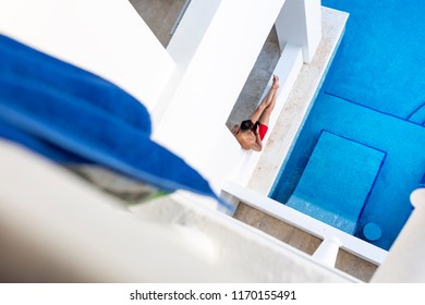 Ariel Shot Of An Attractive And Athletic Young Man Relaxing Next To A Swimming Pool Texting Or Using A Cellphone Or Mobile Phone On A Luxuary Holiday Or Vacation In Mexico