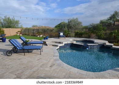 An Arizona Back Yard Featuring A Travertine Tiled Patio With A Pool And Spa.