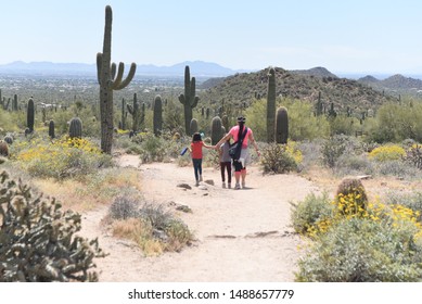 Arizona Desert AZ/ USA 04/07/2019  Family Hiking Arizona Desert With Spring Flowers 