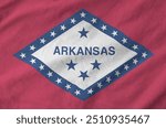 Arkansas US state flag depicted on folded wavy fabric of old cloth close up