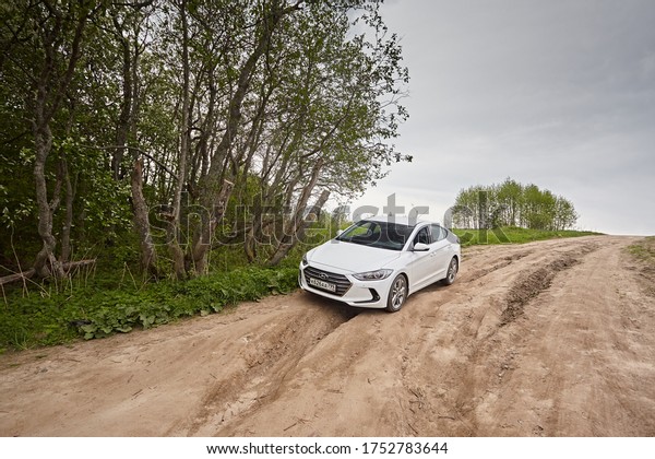 Arkhangelsk region,\
Russia - May 2018: White car Hyundai Elantra rides on a dirt road\
background of cloudy\
sky