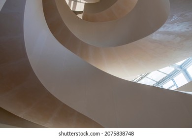 Arles, France-October 2021; Interior low angle view of Luma Arles art center with double circular or helix staircase and exterior with tower building designed by architect Frank Gehry