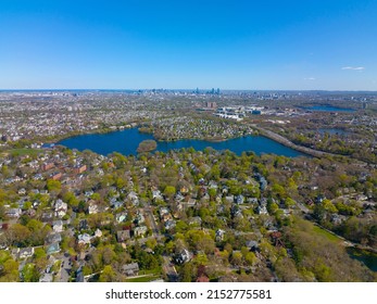 Arlington Heights suburban landscape aerial view in spring with Spy Pond and Boston modern city skyline at the background in historic town of Arlington, Massachusetts MA, USA. 