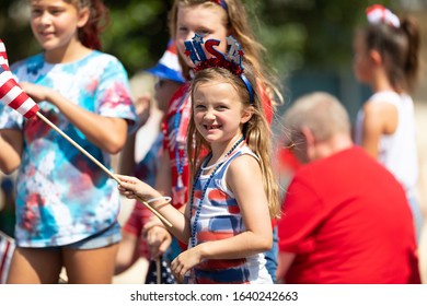 Arlington, Texas, USA - July 4, 2019: Arlington 4th of July Parade, Children on a float, waving american flags at the parade