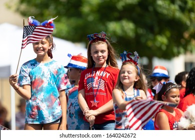 Arlington, Texas, USA - July 4, 2019: Arlington 4th of July Parade, Children on a float, waving american flags at the parade