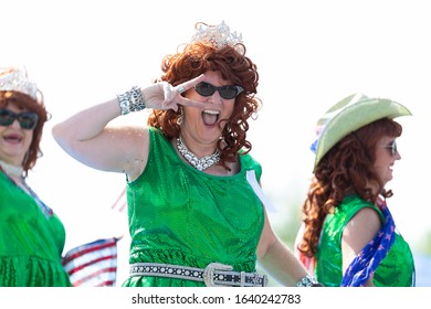 Arlington, Texas, USA - July 4, 2019: Arlington 4th of July Parade, The Pickle parade queens on a float, waving american flags