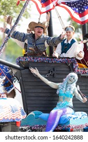 Arlington, Texas, USA - July 4, 2019: Arlington 4th of July Parade, Float in shape of a Pirate ship, with people dress as pirates, waving American flags