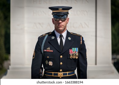 Arlington, VA/USA 7-14-14. United States Honor Guard Soldier With Crisp Dark Blue Uniform With Medals At Arlington National Cemetery With The Tomb Of The Unknown Soldier