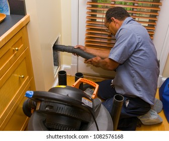 ARLINGTON, VIRGINIA, USA - JULY 2, 2009: Worker With Vacuum During Duct Cleaning In Home.