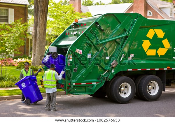 ARLINGTON, VIRGINIA,\
USA - JUNE 23, 2009: Workers empty recycling bins into truck in\
residential\
neighborhood.