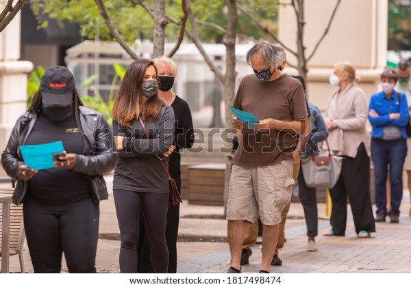 ARLINGTON, VIRGINIA, USA - SEPTEMBER 18, 2020:\
People line up and look at sample ballots during first day of early\
voting, 2020 presidential\
election.