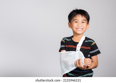 Arm broken. Little cute kid boy 5-6 years old hand bone broken from accident with arm splint in studio shot isolated white background, Asian children preschool injured after accident, health concept